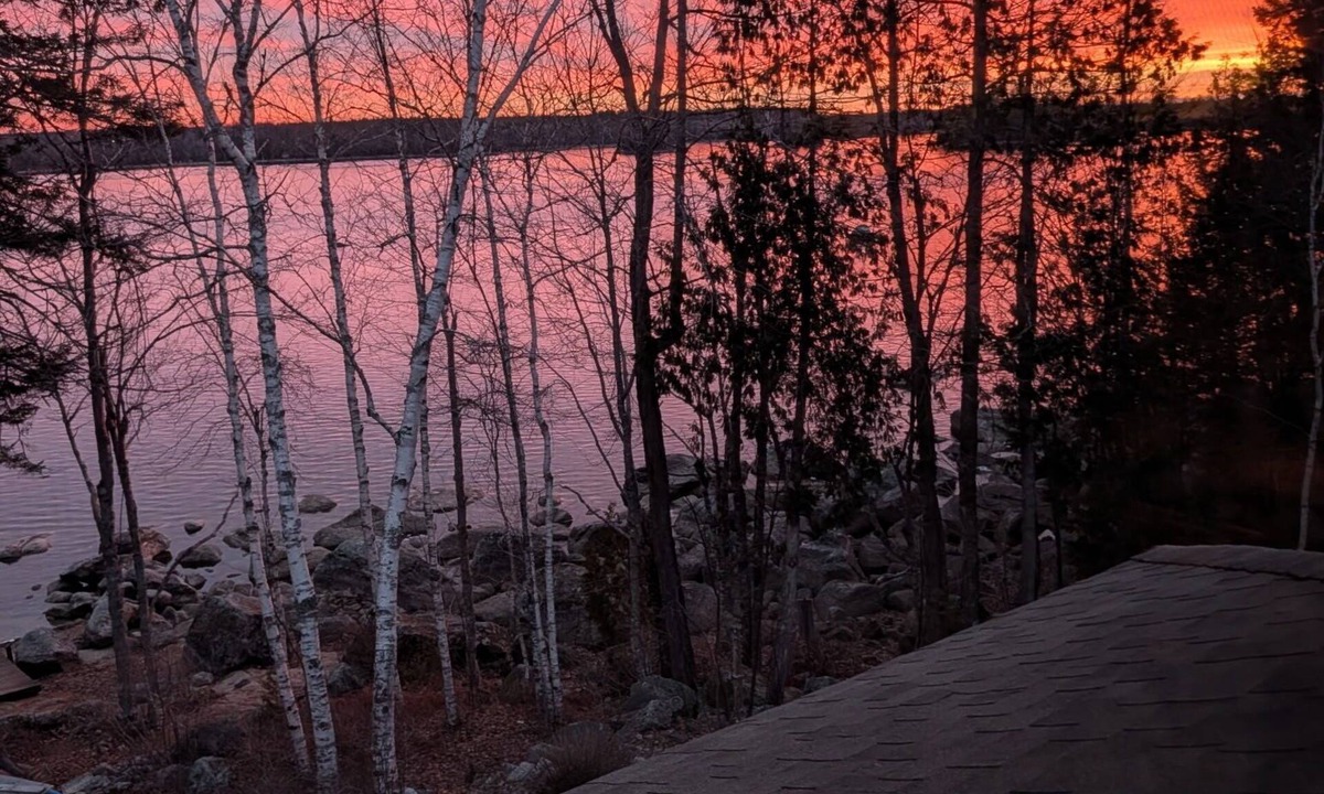 Ellsworth House | Stunning lakefront home with serene outside sitting area overlooking the water.