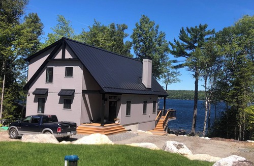 Ellsworth House | Stunning lakefront home with serene outside sitting area overlooking the water.
